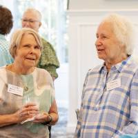 Claudia Bajema and Dorothy Armstrong standing at event and chatting